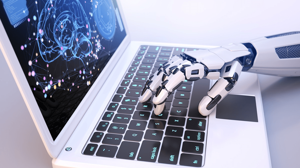 Mão de robô digitando em um notebook, representando o uso de inteligência artificial na triagem automatizada de currículos