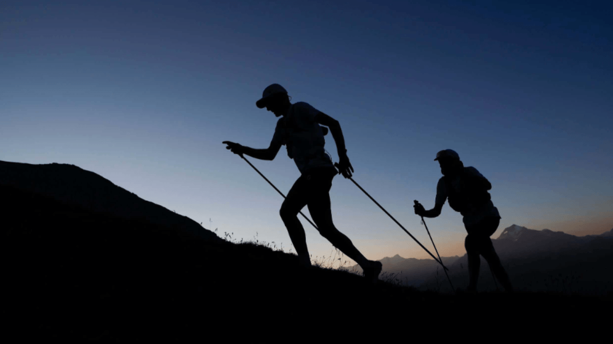 Trecho de trilha da UTMB World Series ao entardecer com atletas de trail running