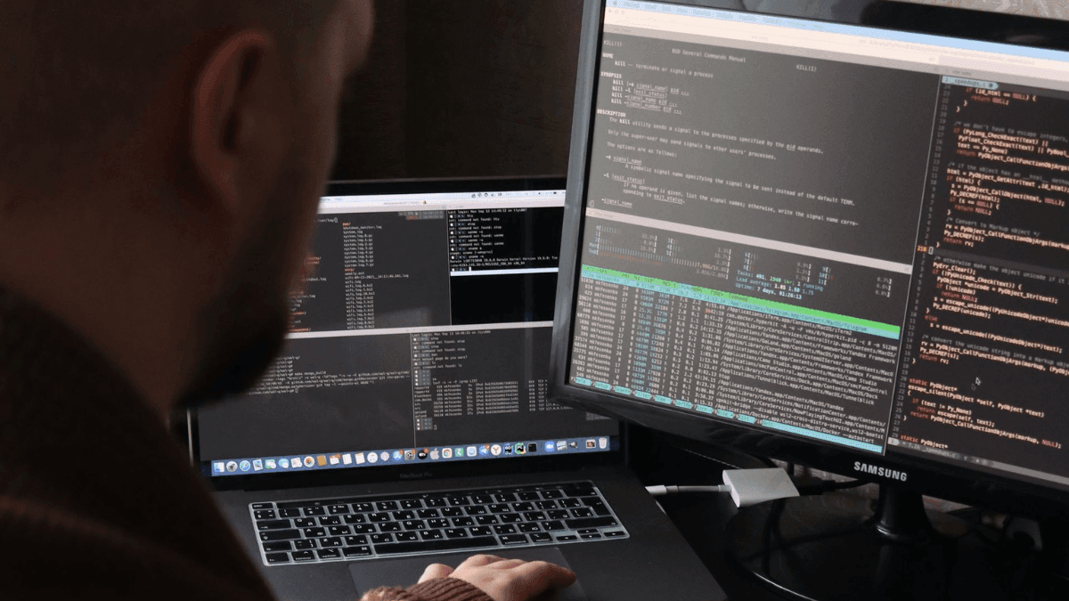 Desenvolvedor de tecnologia trabalha com códigos em notebook e computador