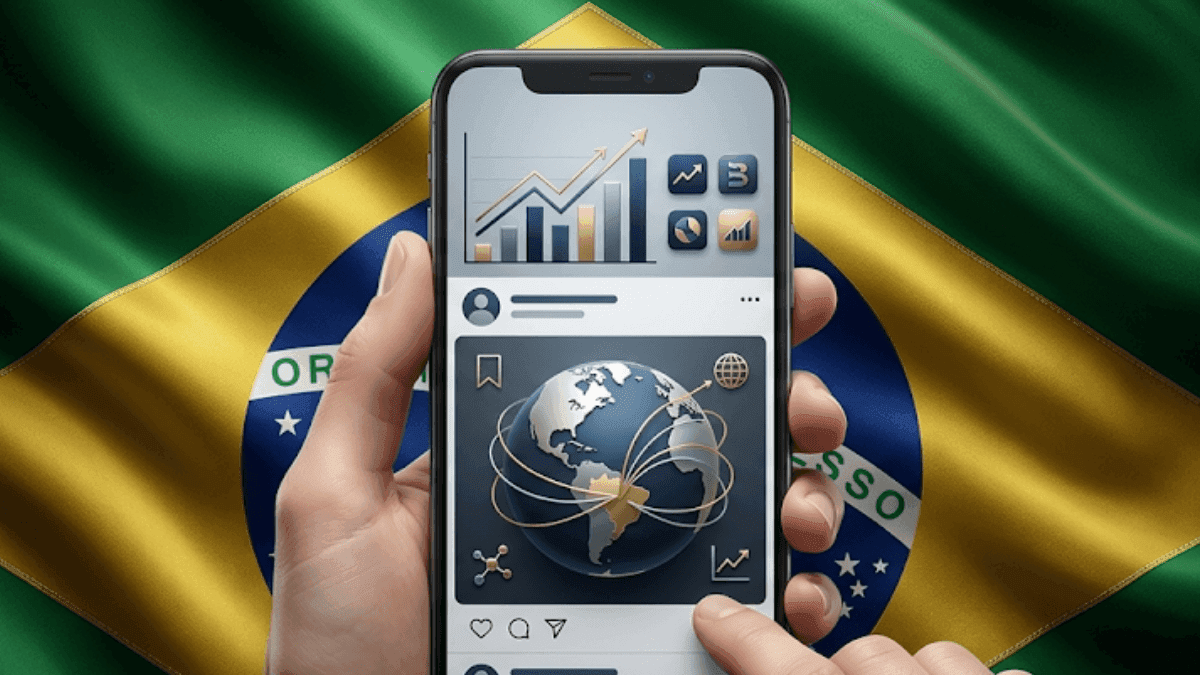 Mão segurando celular com rede social e gráficos diante da bandeira do Brasil